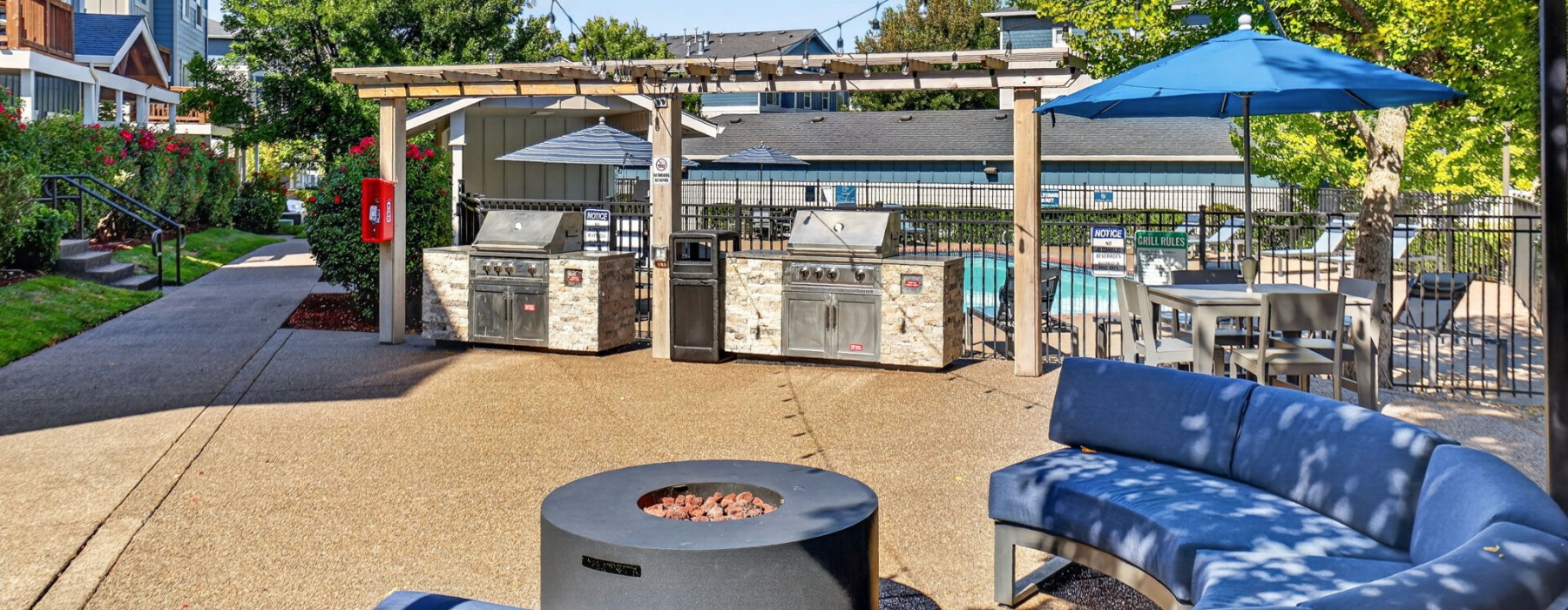 a grill area with a fire pit and couch